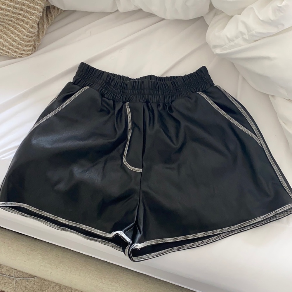 Black faux leather shorts with a white hem
